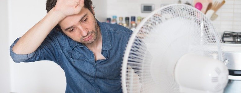 man in front of a fan wishing for ac