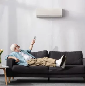How Heat Pumps Work In the Summer; A man enjoying the comfortable air in his home due to a heat pump